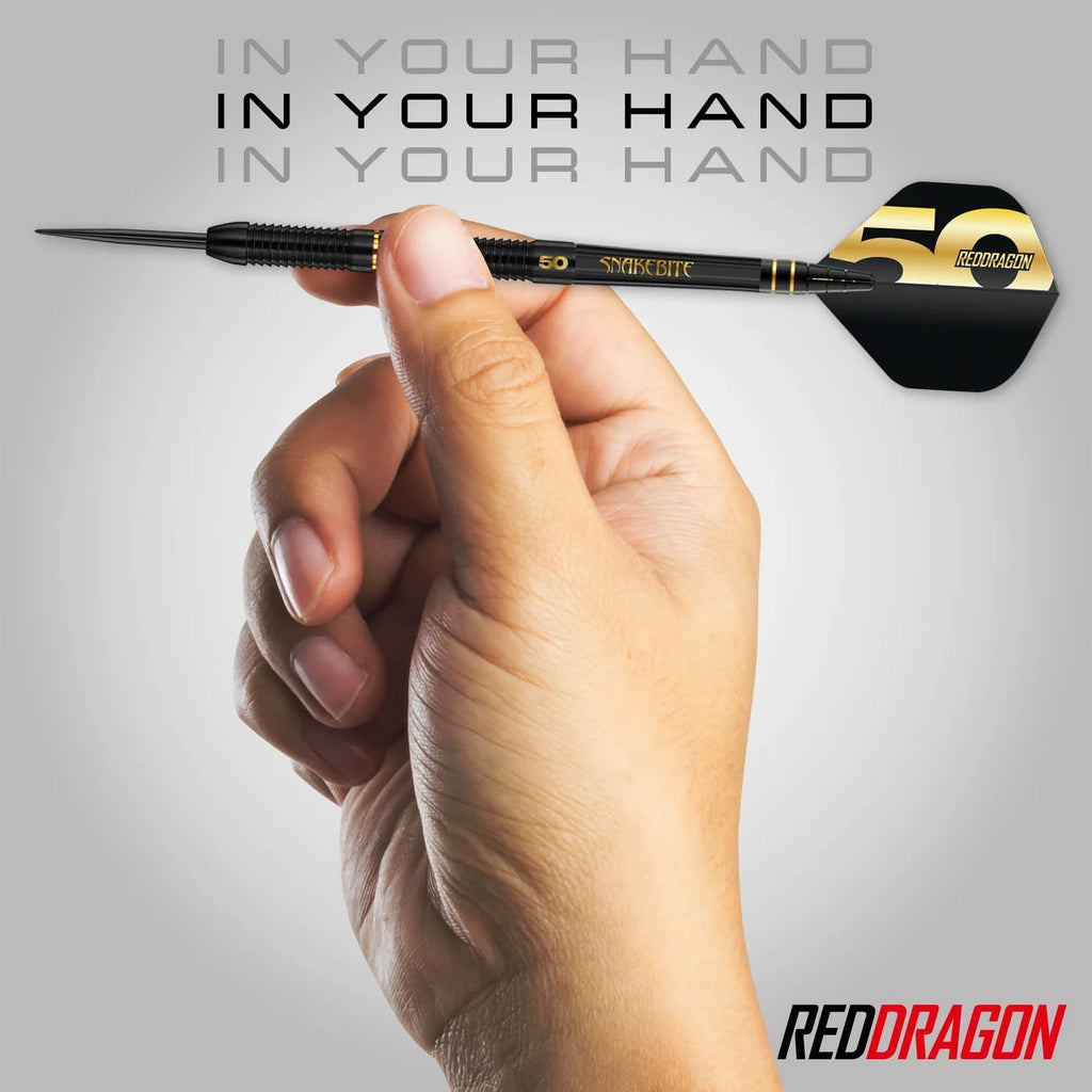 A hand holds the Peter Wright 50 Year Player Edition Box dart with a black and gold design, featuring Professional Darts Corporation branding, set against a gray background with "IN YOUR HAND" above and the REDDRAGON logo at bottom right.