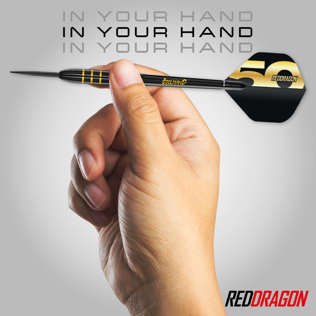 A hand holds a black and yellow dart from the Luke Humphries 50 Year Player Edition Box by Professional Darts Corporation; “IN YOUR HAND” is repeated three times above, with the Professional Darts Corporation logo in the bottom right corner.
