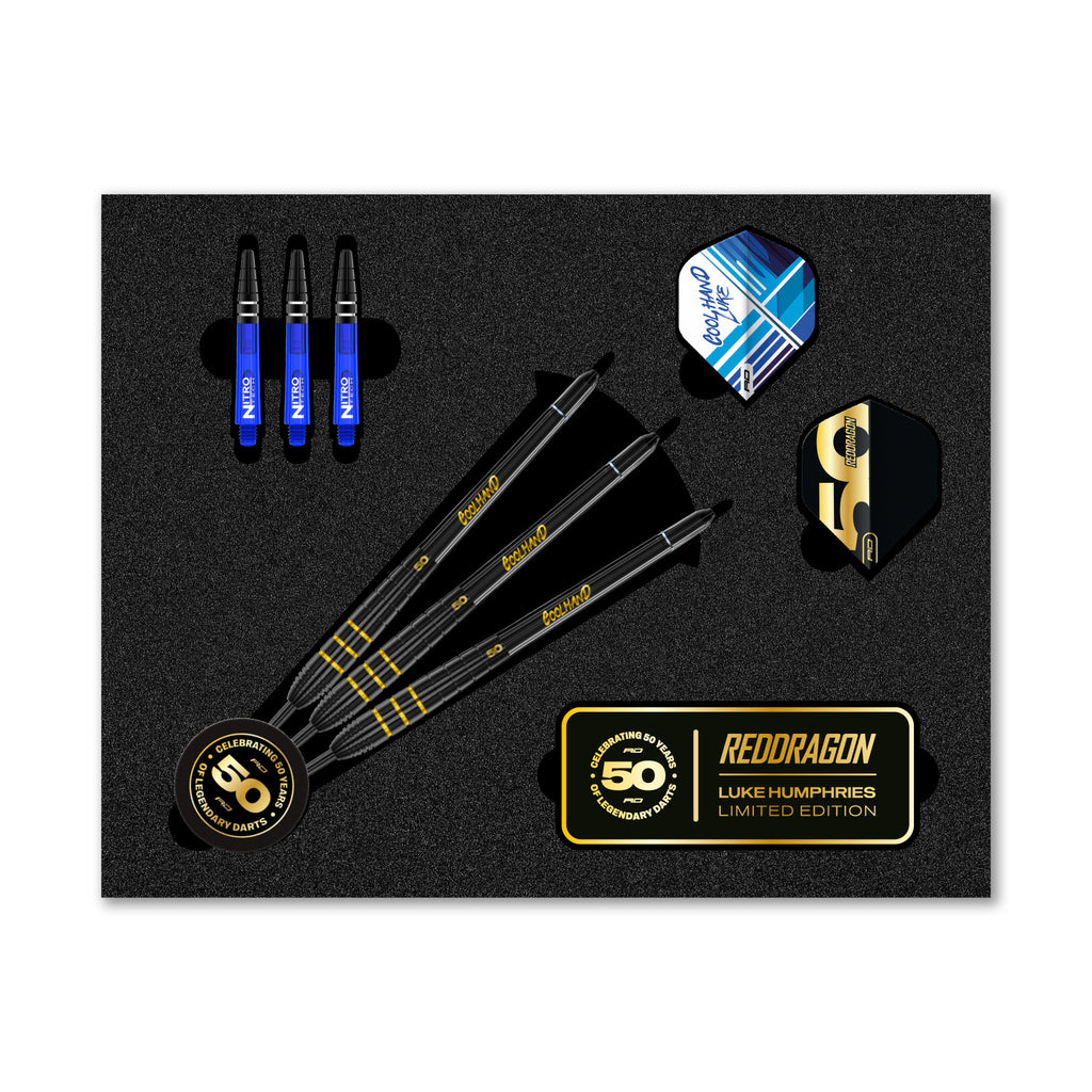 The Professional Darts Corporation Luke Humphries 50 Year Player Edition Box includes three black darts with gold text, blue and black stems, flights, and a gold pin in a foam insert. The packaging features the Luke Humphries Limited Edition branding.
